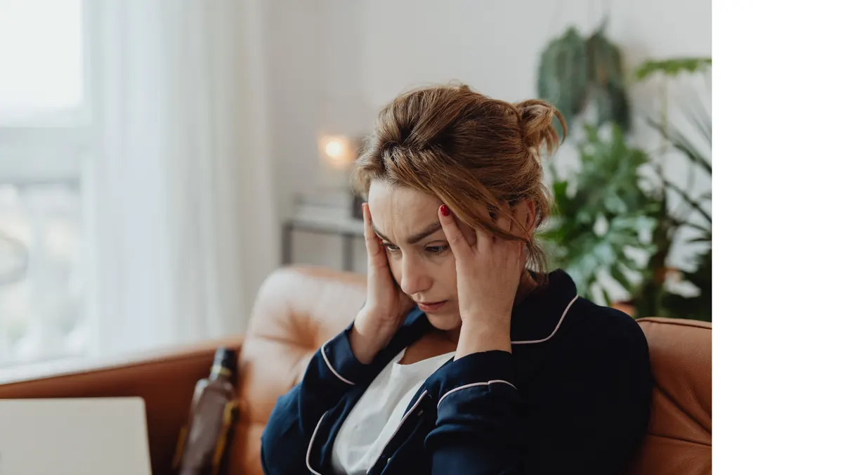Erschöpfte Frau auf einer Couch – Symbolbild für chronischen Stress